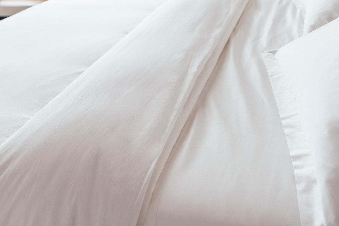 Lofted white natural fill duvet on a bed with organic cotton bedding