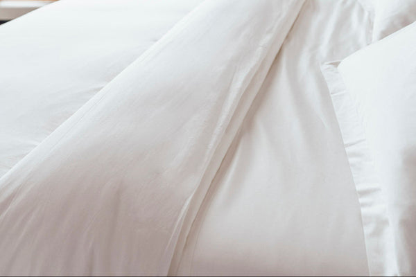 Lofted white natural fill duvet on a bed with organic cotton bedding