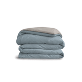 Down for Good Essential duvet cover panels, folded and stacked, in Blue Haze and Fog organic cotton.