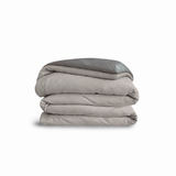 Down for Good Essential duvet cover panels, folded and stacked, in Fog and Riverbed organic cotton.