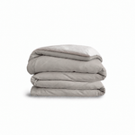 Down for Good Essential duvet cover panels, folded and stacked, in Fog and Shell organic cotton.