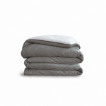 Down for Good Essential duvet cover panels, folded and stacked, in Riverbed and White organic cotton.