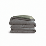 Down for Good Essential duvet cover panels, folded and stacked, in Riverbed and Willow organic cotton.