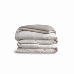Down for Good Essential duvet cover panels, folded and stacked, in Shell and Fog organic cotton.
