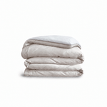 Down for Good Essential duvet cover panels, folded and stacked, in Shell and White organic cotton.