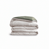 Down for Good Essential duvet cover panels, folded and stacked, in Shell and Willow organic cotton.