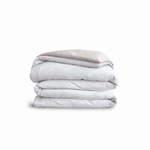 Down for Good Essential duvet cover panels, folded and stacked, in White and Shell organic cotton.