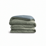 Down for Good Essential duvet cover panels, folded and stacked, in Willow and Blue Haze organic cotton.