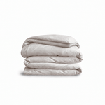 Down for Good Essential duvet cover panels, folded and stacked, in Shell organic cotton.